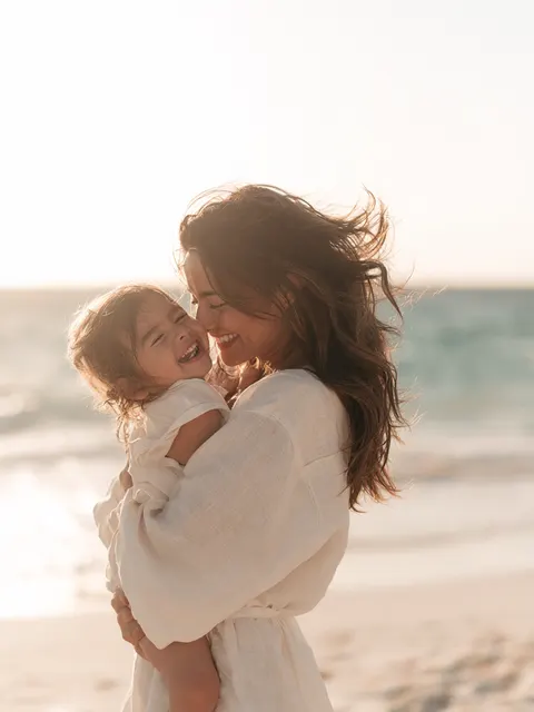 Imagen ilustrativa de mommy makeover: modelo en la playa al atardecer